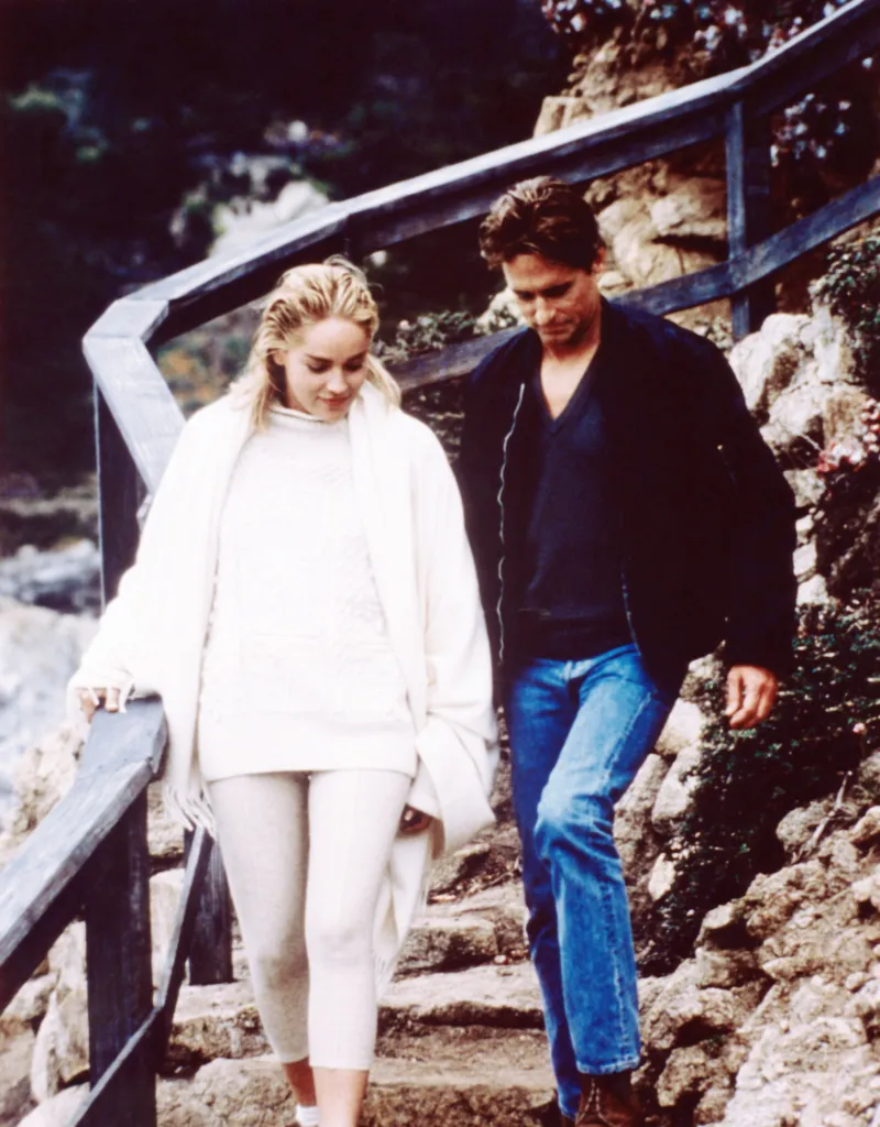 Sharon Stone and Michael Douglas walking down outdoor stone stairs with wooden railings in Basic Instinct.