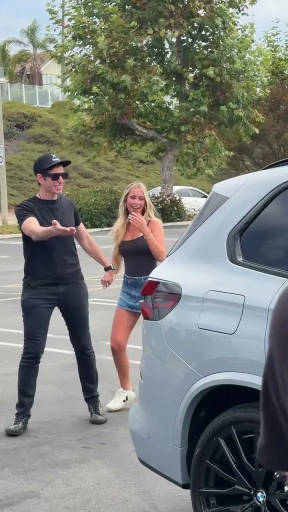 HGTV star and his 16-year-old daughter smiling near her new BMW.