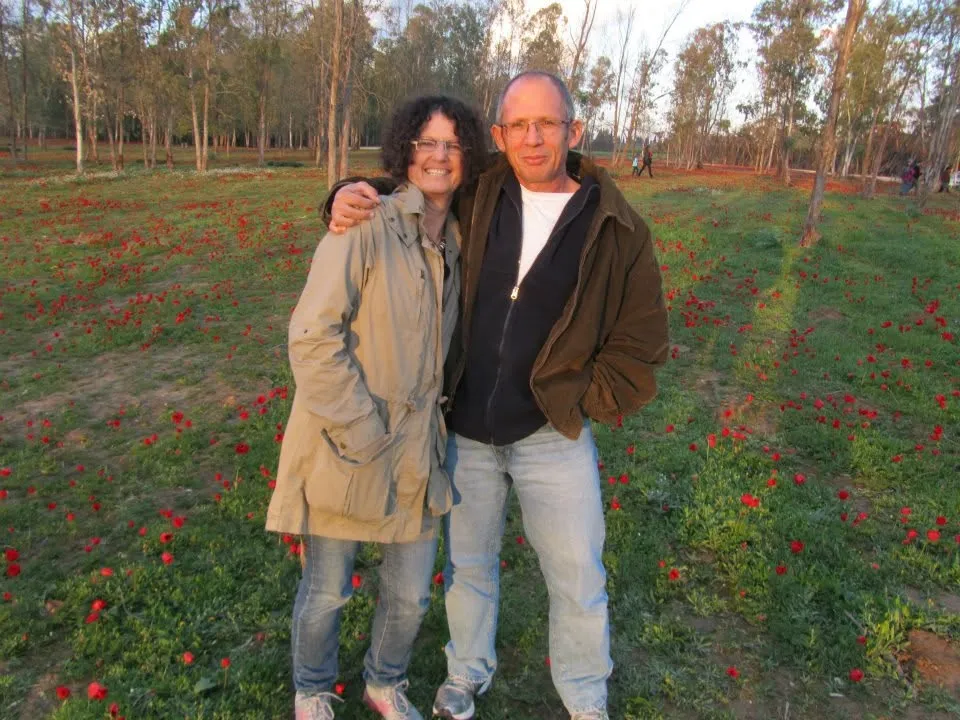 Shoshan Haran and her husband, Avshalom, pose in an anemone field in Kibbutz Be'eri.