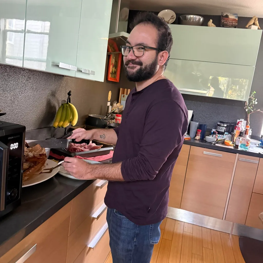 Jonathan McKinsey in a kitchen, carving meat.