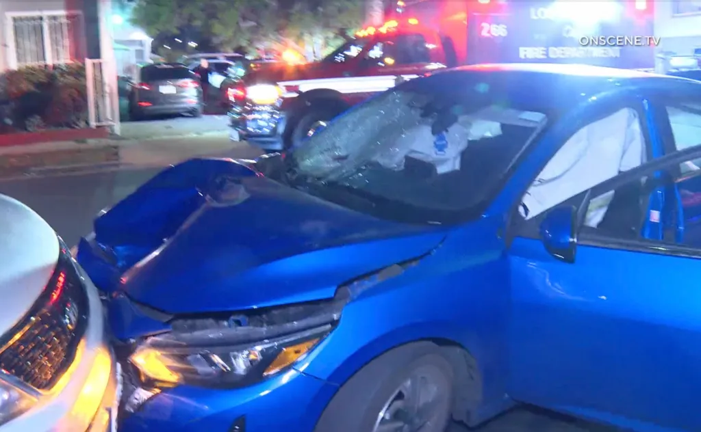 A blue car with heavy front-end damage and a shattered windshield at a hit-and-run crash scene in Hyde Park.