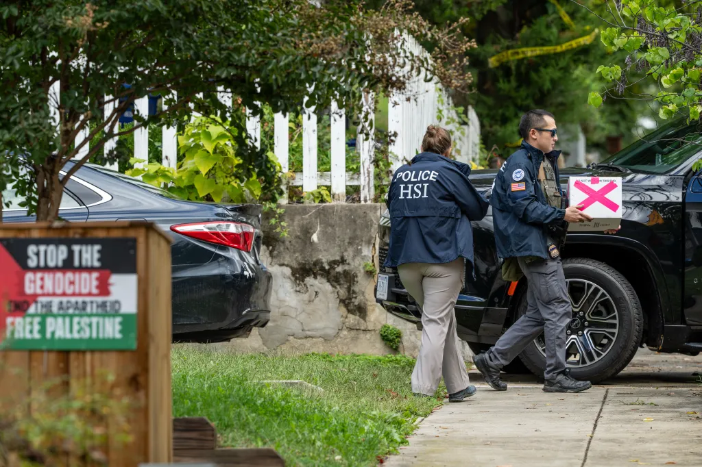 Homeland Security officers carry boxes during a search outside Rep. Ilhan Omar's Washington residence.