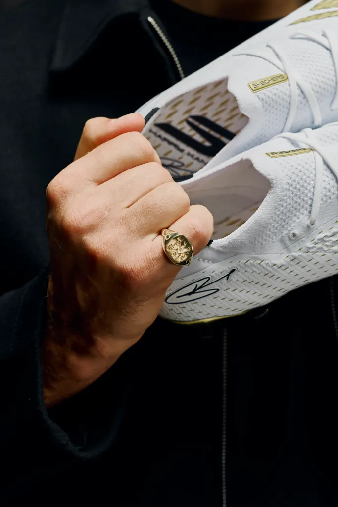 Harry Kane holds a pair of custom Skechers football boots crafted in 24-carat gold leaf.