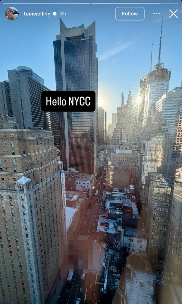 A view of New York City buildings from a window, with a blurred reflection near the bottom.