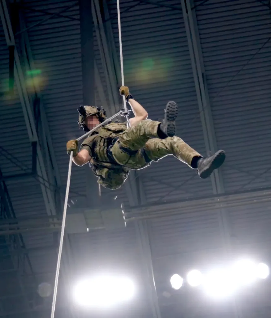 An airman rappels from the Alamodome stadium rafters during an earlier demonstration.