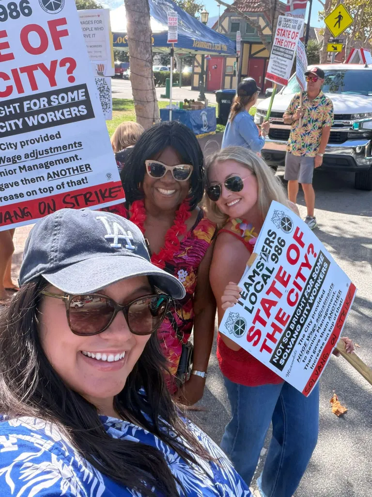 Solvang leaders and a union bargaining team pose with strike signs.