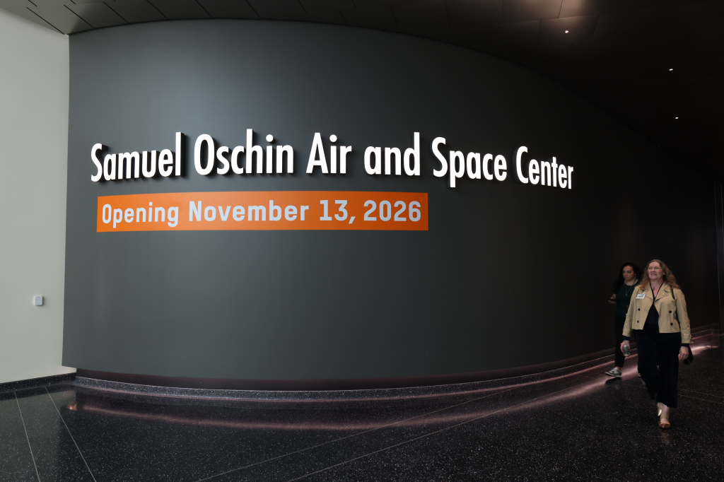 Entrance sign for the Samuel Oschin Air and Space Center with two women walking by.