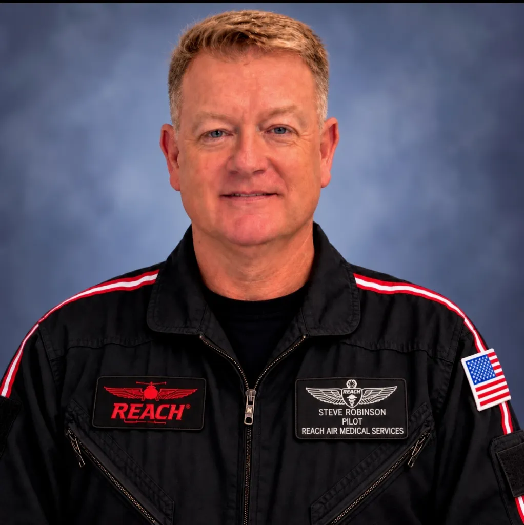 A portrait of Steve Robinson, a pilot for Reach Air Medical Services, wearing a black uniform.
