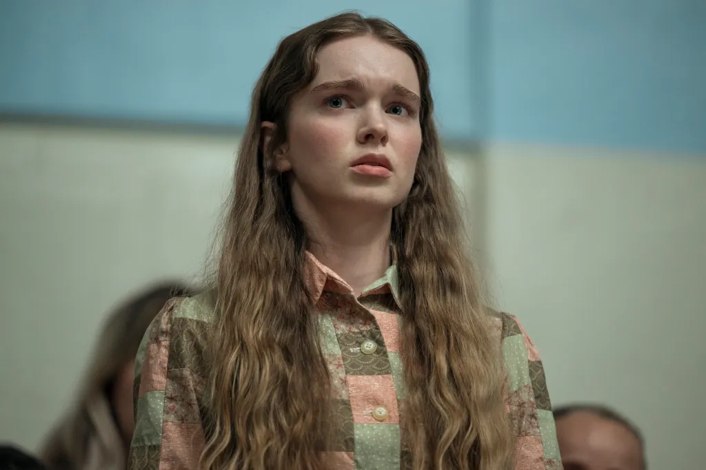 Summer H. Howell as Carrie looking upward with a concerned expression.
