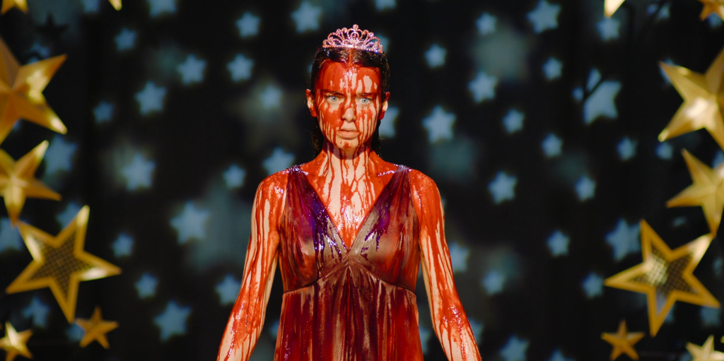 Summer H. Howell as Carrie covered in blood, wearing a tiara, against a starry backdrop.