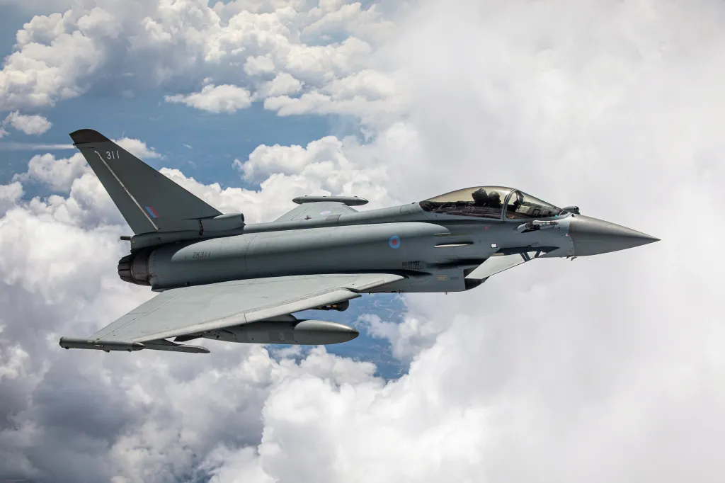 A Royal Air Force Typhoon aircraft flying above a layer of clouds.
