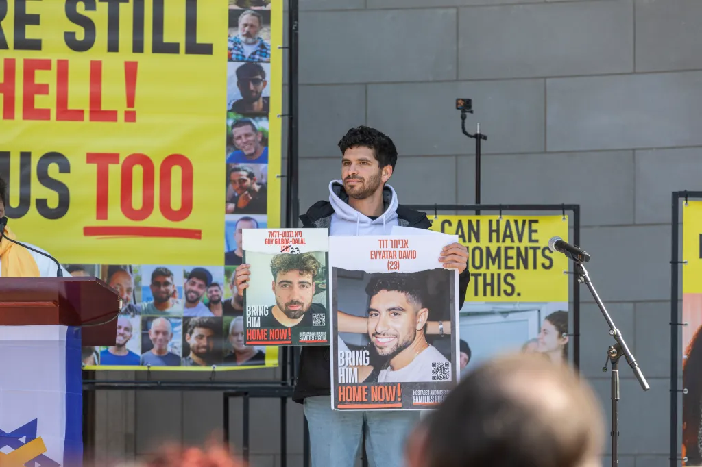 Gal Gilboa-Dalal and Ilay David hold posters of hostages Guy Gilboa-Dalal and Evyatar David at a rally in Central Park.