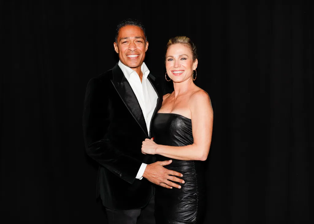 T. J. Holmes and Amy Robach pose together backstage at an event.