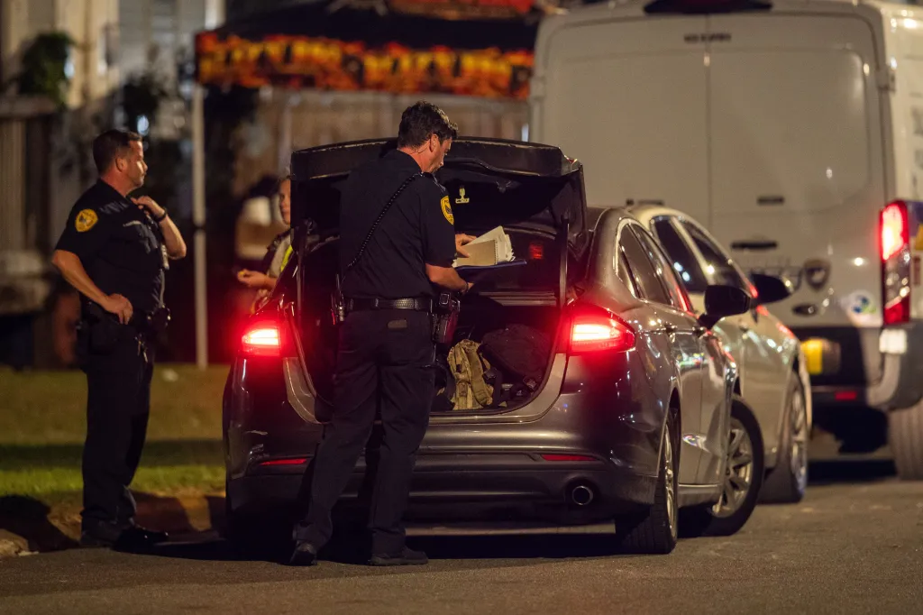 Police officers investigate the scene of a shooting.