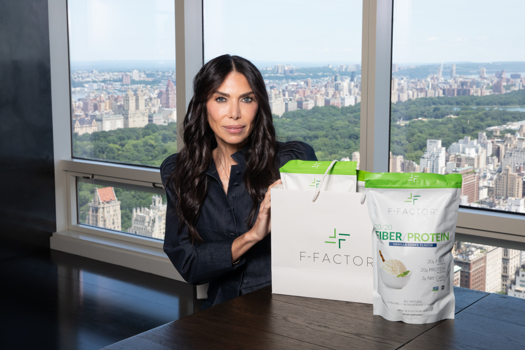 Tanya Zuckerbrot poses in her Midtown apartment with F-Factor products against a New York City backdrop.