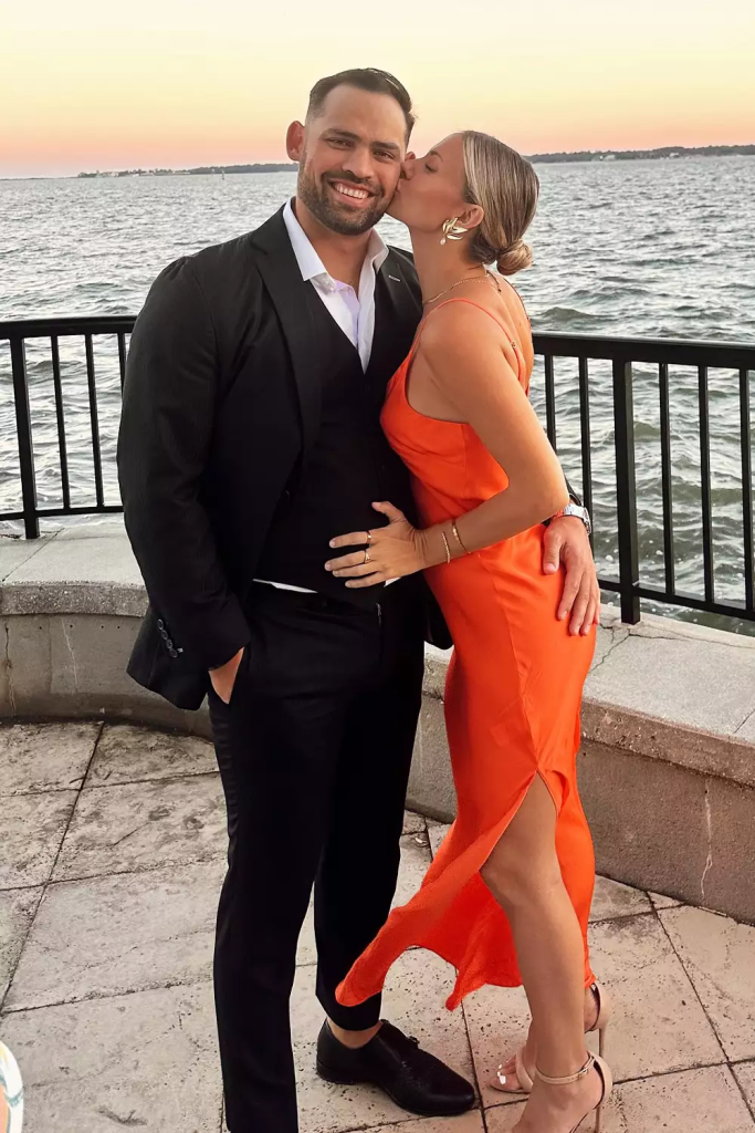 Taylor Ann Green kisses Gaston Rojas on the cheek near a body of water.