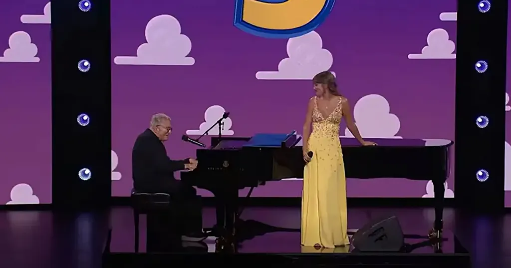 Taylor Swift in a yellow daisy-embellished dress performing a surprise duet with Randy Newman at the 'Toy Story 5' premiere.