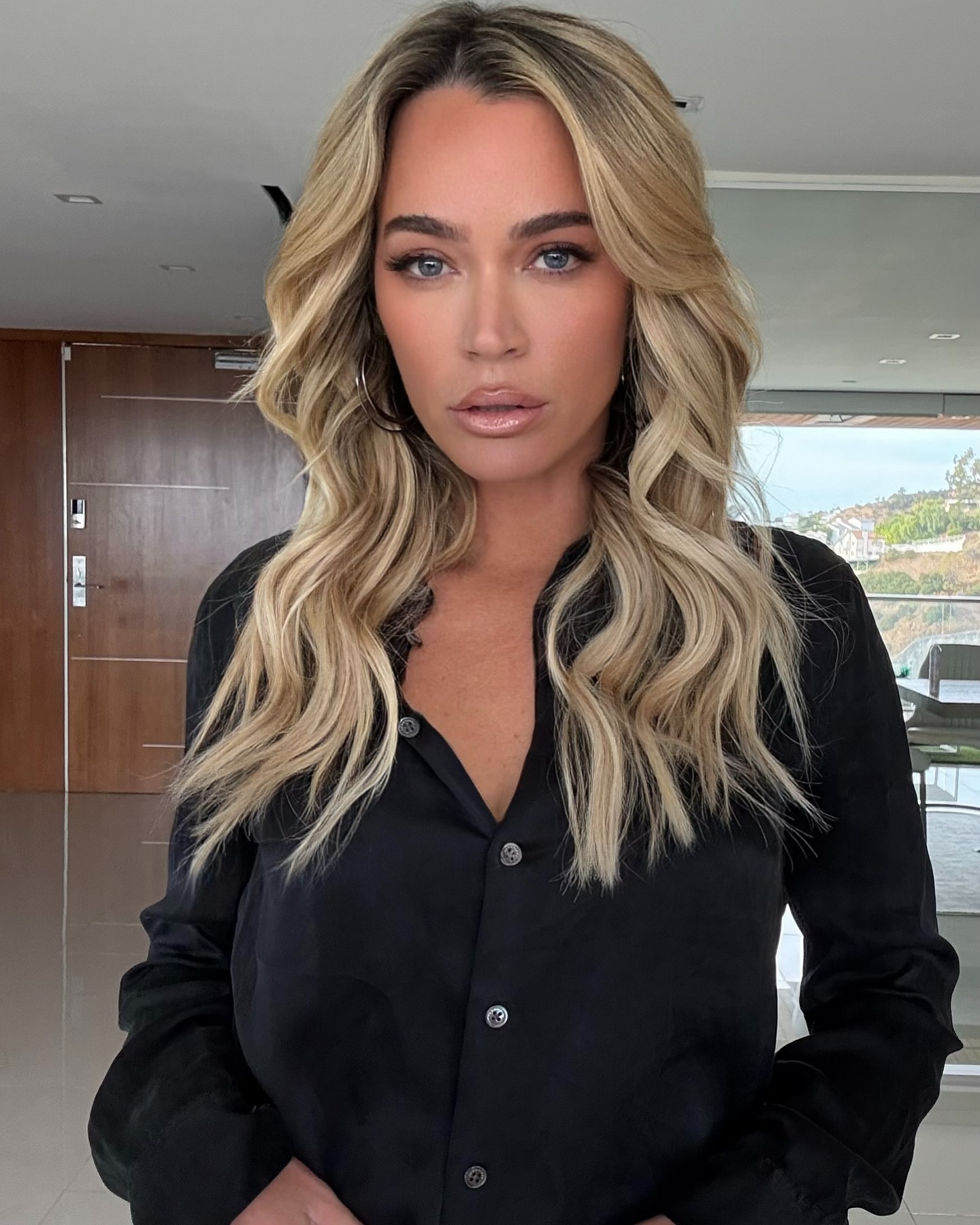 Teddi Mellencamp wearing a black button-down shirt.