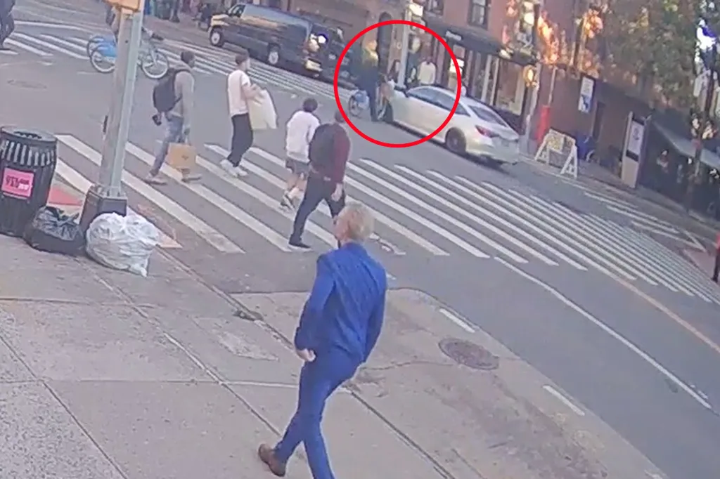 An unmarked NYPD car hits a cyclist at a city intersection.