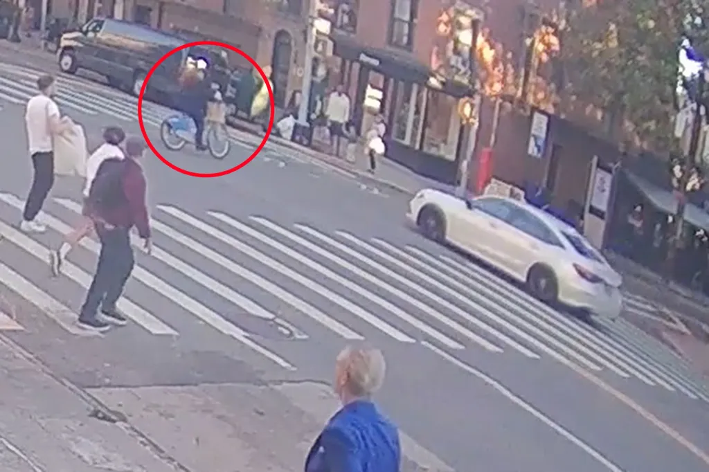 Video capture of an unmarked NYPD car slamming into a cyclist at a street corner.