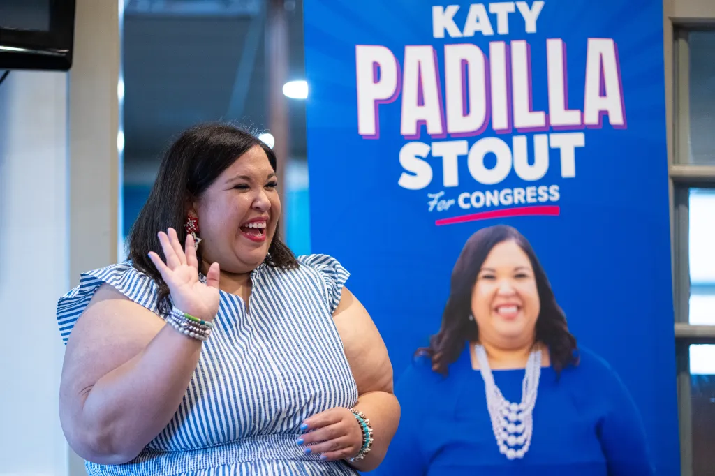 Texas Democratic congressional candidate Katy Padilla Stout waves to supporters in front of a campaign sign.