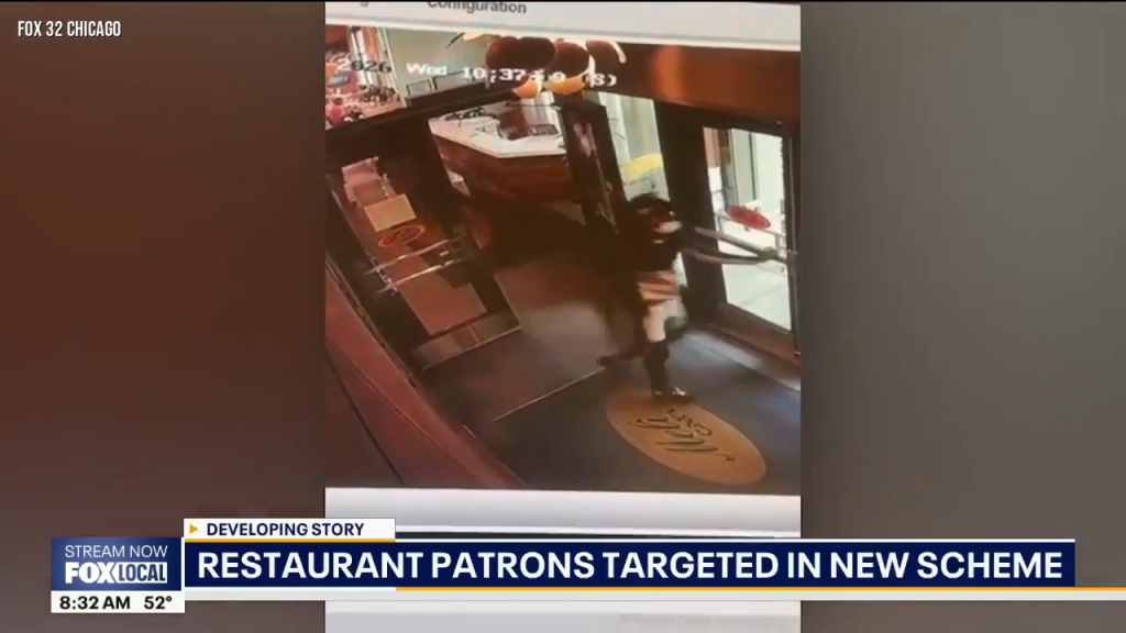 Surveillance footage of a person walking through the doors of a restaurant.