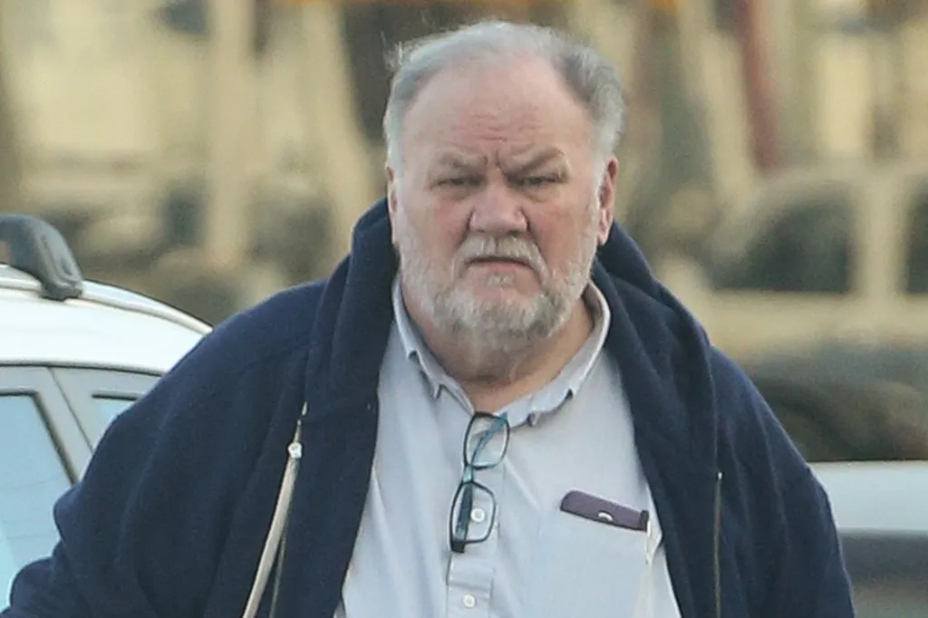 Thomas Markle wearing a blue zip-up sweater over a light shirt with glasses tucked into the collar.