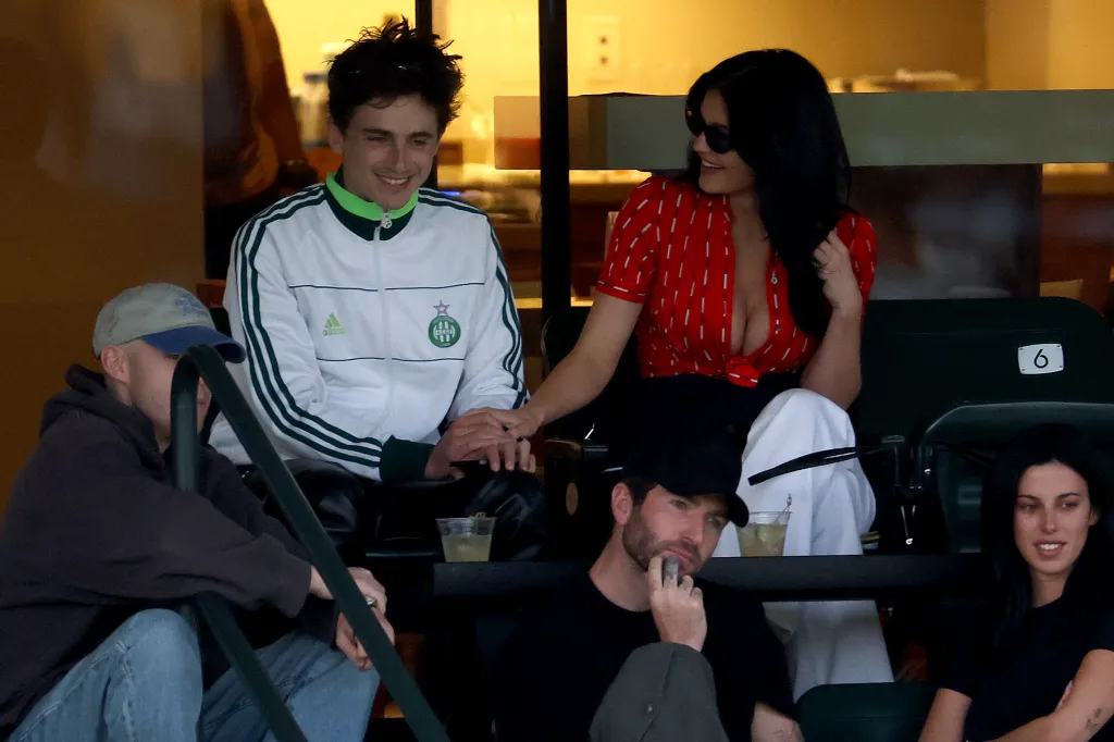 Timothée Chalamet and Kylie Jenner hold hands while attending a tennis match.