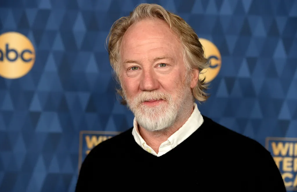 Timothy Busfield stands in front of a blue backdrop with ABC logos.