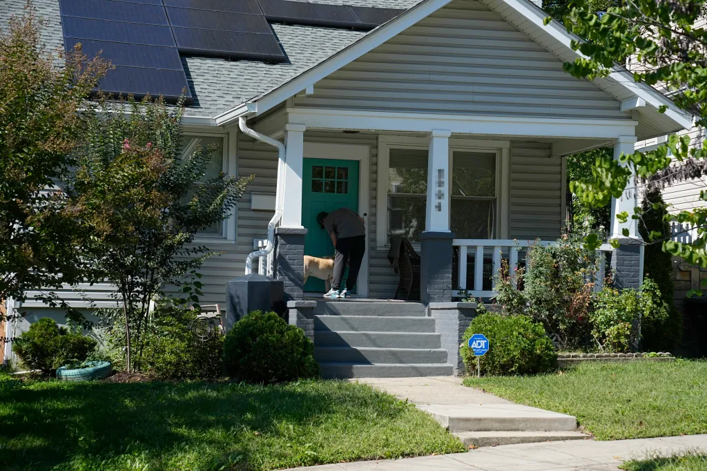 Timothy Mynett, husband of U.S. Rep. Ilhan Omar, stands with his dog on the porch of their Washington, D.C. home.