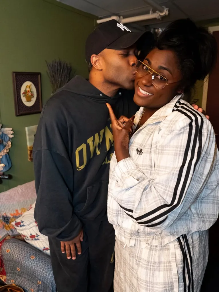 Todrick Hall kisses Danielle Brooks on the cheek as she smiles and points to her cheek.