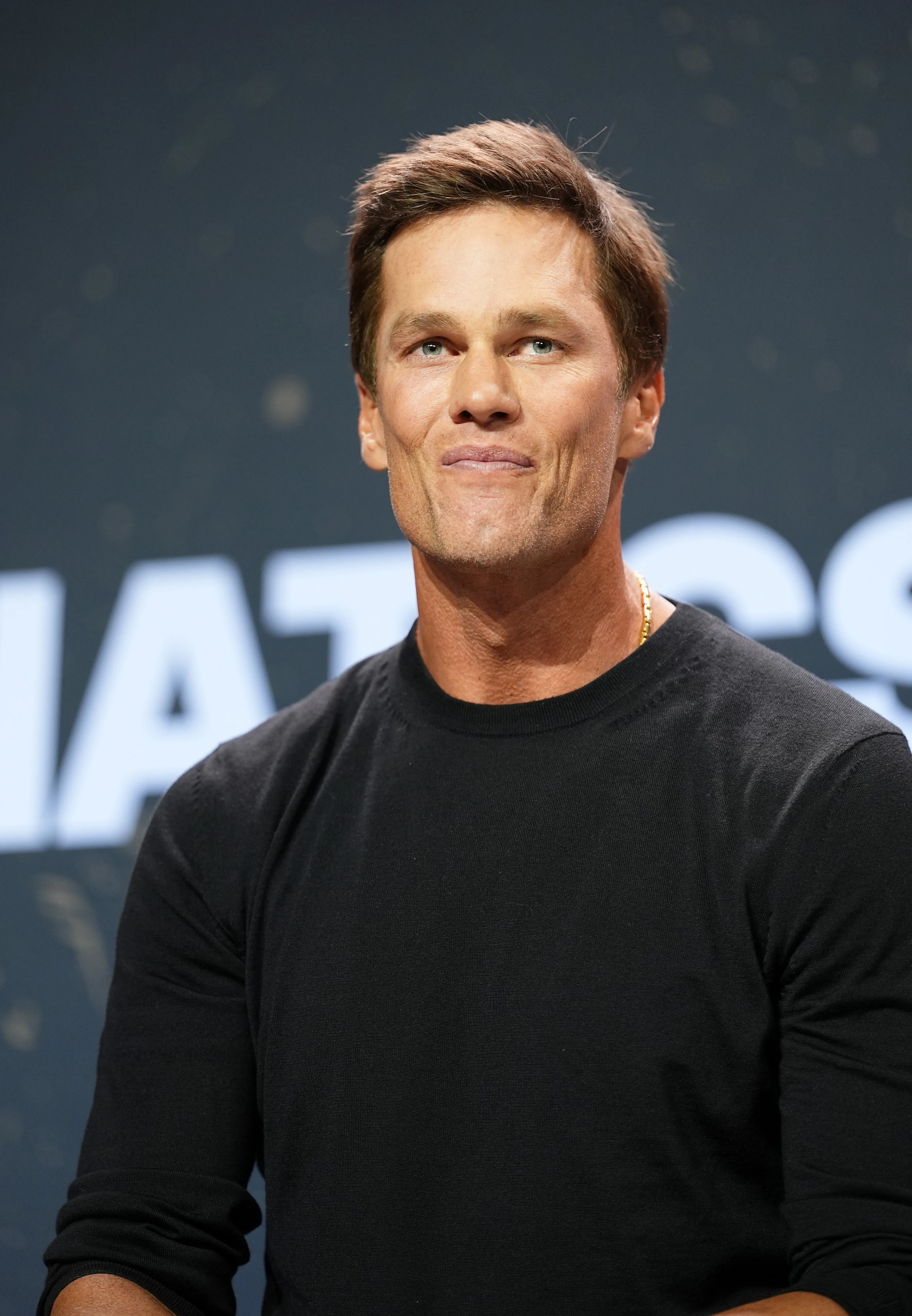 Tom Brady speaking onstage at a panel.