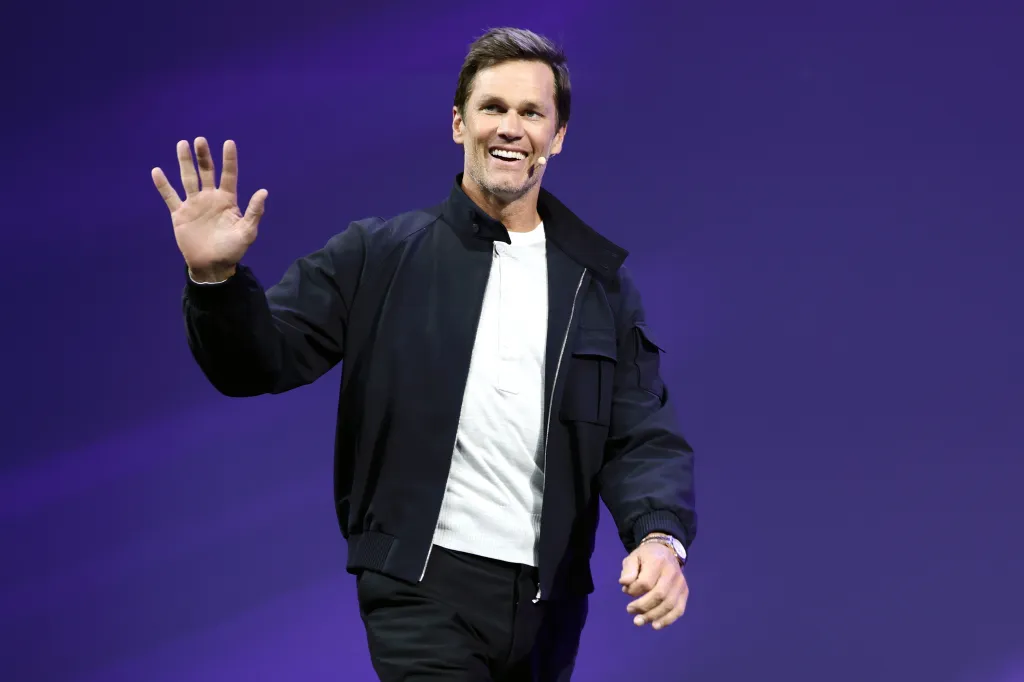 Tom Brady smiles and waves on stage at the OMR Festival.