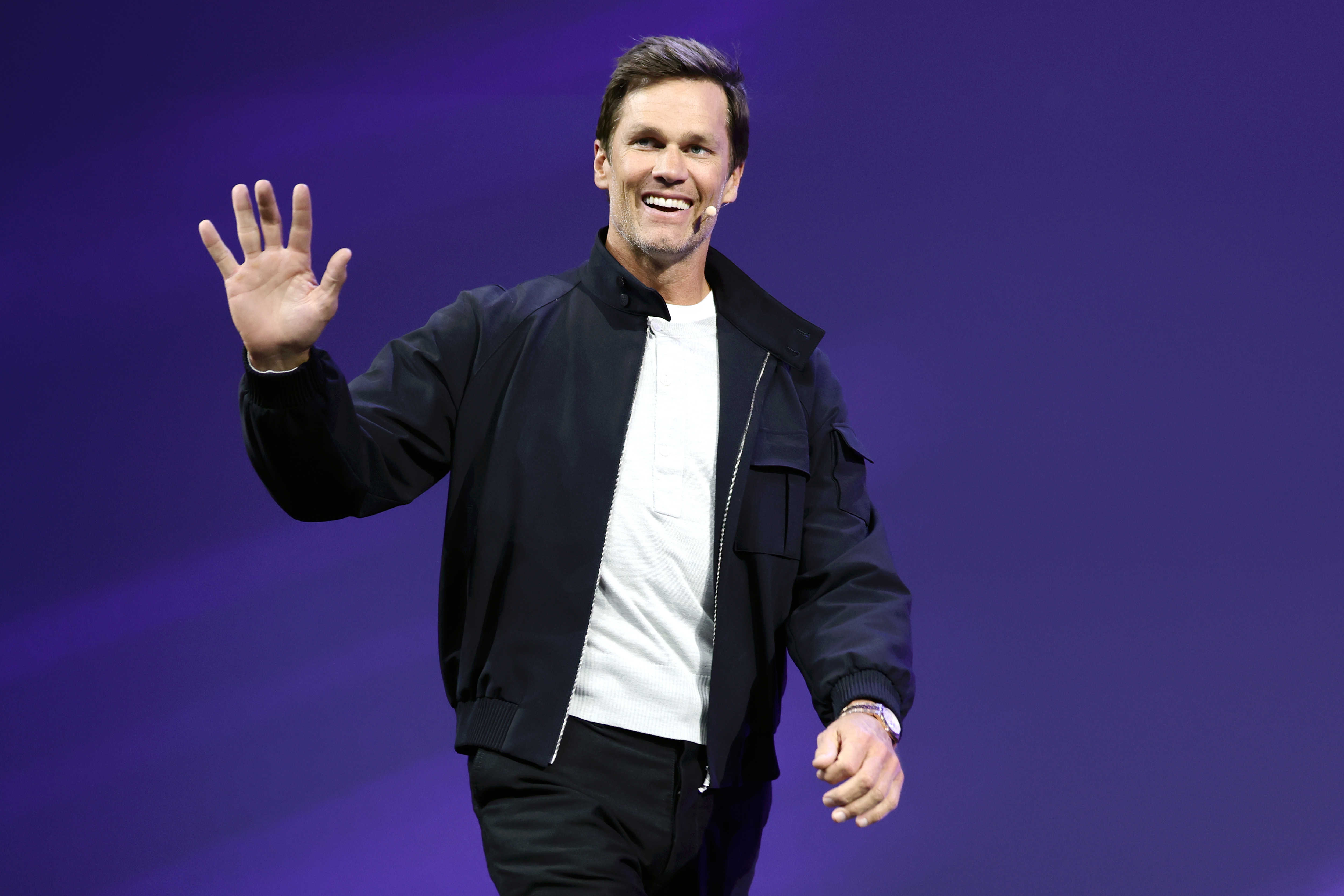 Tom Brady waves to the audience on stage at the OMR Festival in Hamburg, Germany.