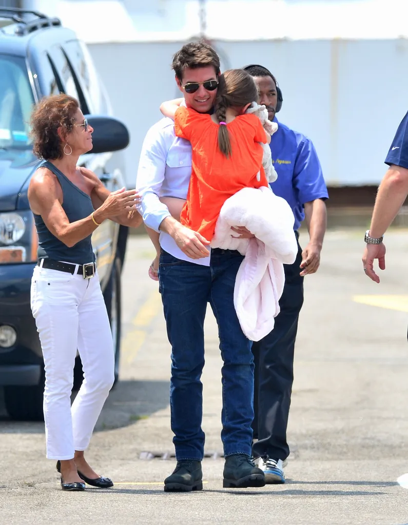Tom Cruise holds and hugs Suri Cruise as they prepare to leave by helicopter.
