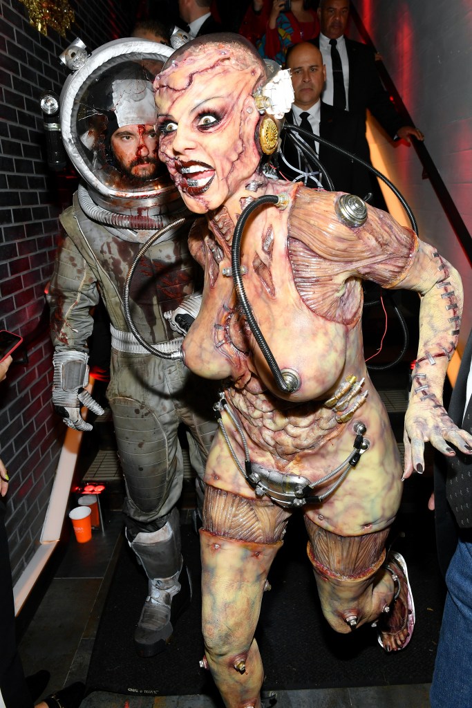 Tom Kaulitz and Heidi Klum attend a Halloween party in elaborate, gory sci-fi costumes.