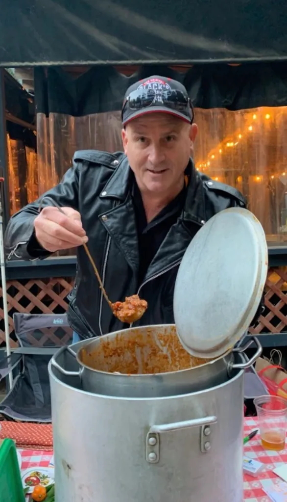 Tom O'Bryan holding a ladle of food above a large pot.
