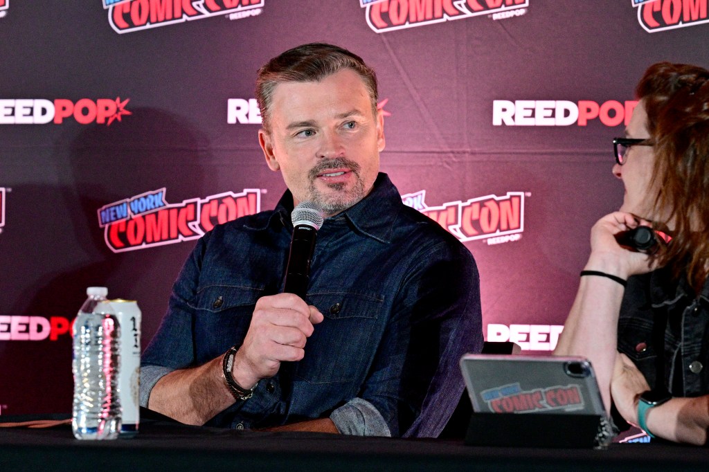 Tom Welling speaks into a microphone at New York Comic Con.