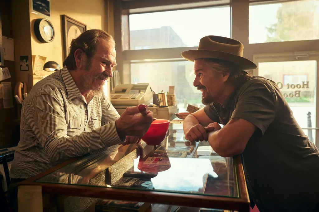 Tommy Lee Jones as Frog and Ethan Hawke as Lee Raybon face each other across a shop counter.