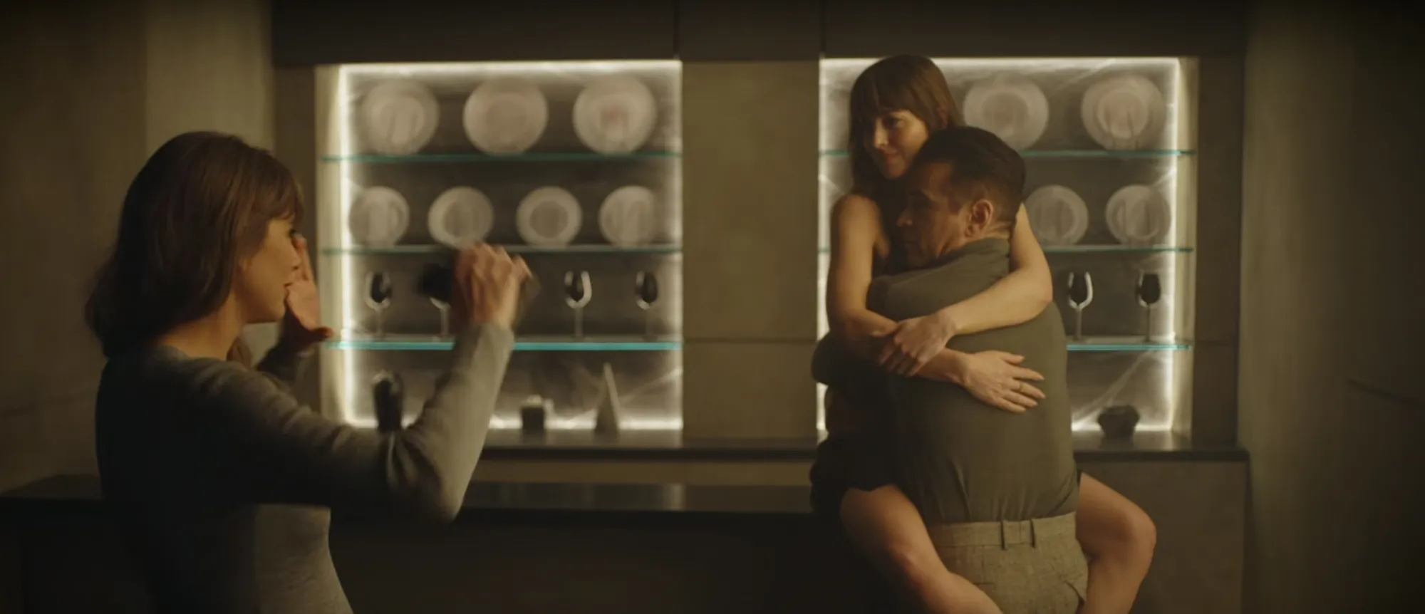 Taylor Swift directs a scene for the 'Patient Zero' music video, featuring actors embracing in front of illuminated shelving.