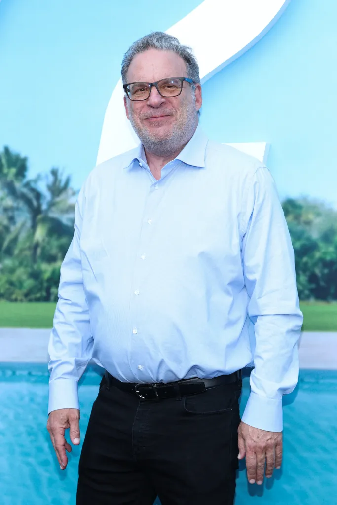 Comedian Jeff Garlin poses at a film premiere in a light blue button-down shirt and black pants.
