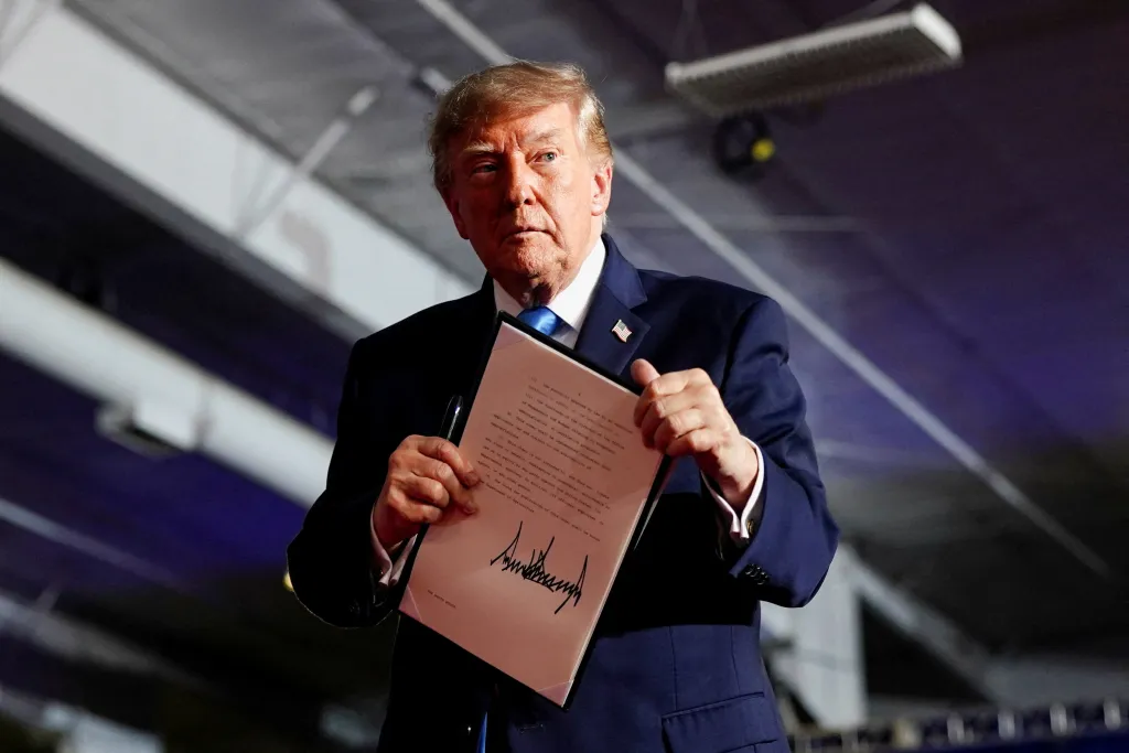 US President Donald Trump holds an Executive Order after signing it onstage during a rally in Grand Island, Nebraska.