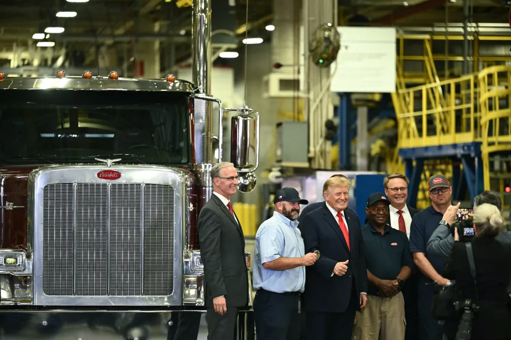 President Donald Trump poses for a photo with employees during a tour of the Peterbilt Motors facility in Denton, Texas.