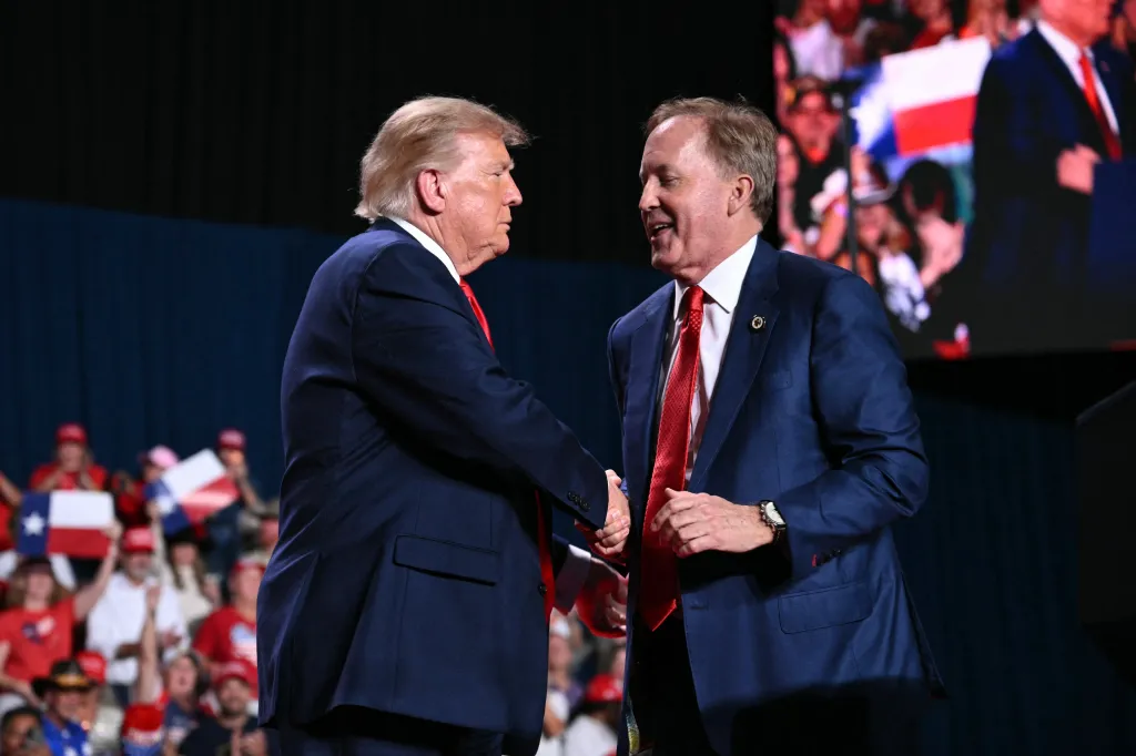 U.S. President Donald Trump shakes hands with Republican candidate for U.S. Senate Ken Paxton during a campaign rally.