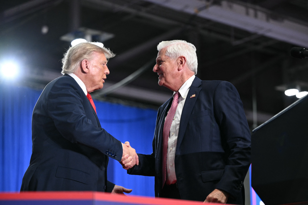 U.S. President Donald Trump shakes hands with Republican candidate for New York governor Bruce Blakeman at a campaign rally.