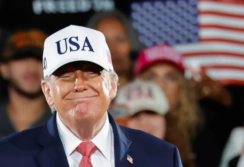 US President Donald Trump smiles as he looks at supporters after leaving the stage during a campaign rally.