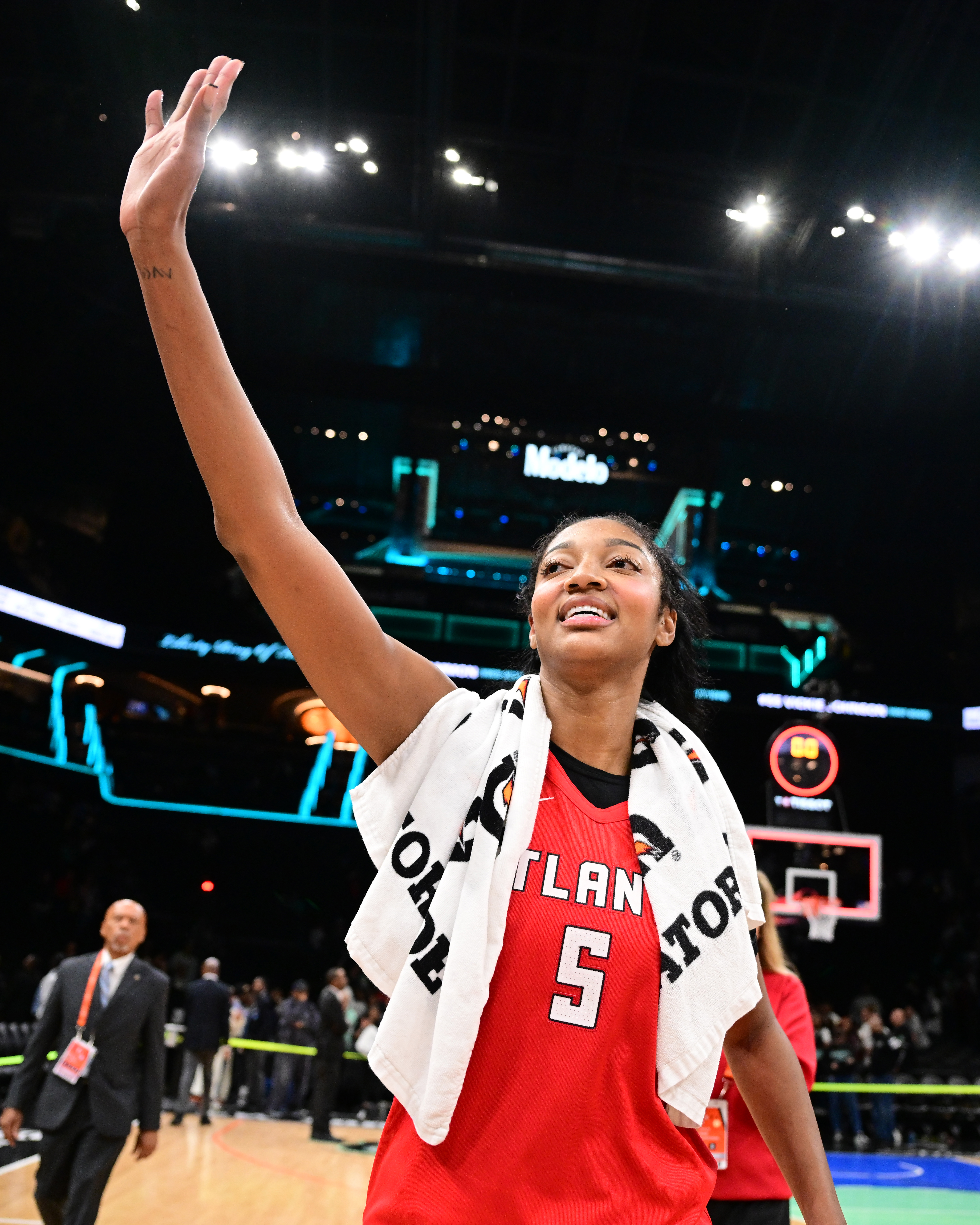 Angel Reese smiling and waving after the game against the New York Liberty.