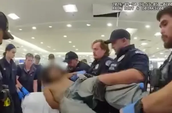 Vancouver Police officers carry a suspect who was hiding in the ceiling of the Vancouver Mall.