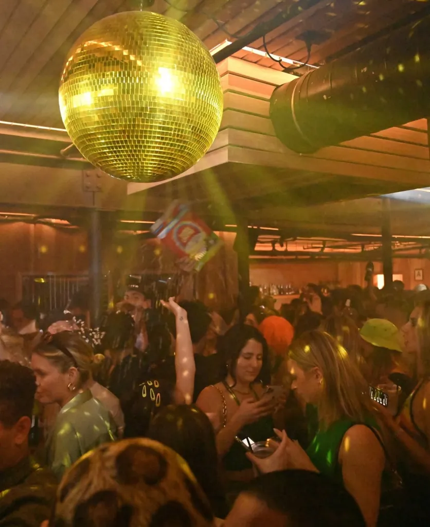 People socializing under a large disco ball inside The Victorian on Main Street in Santa Monica.