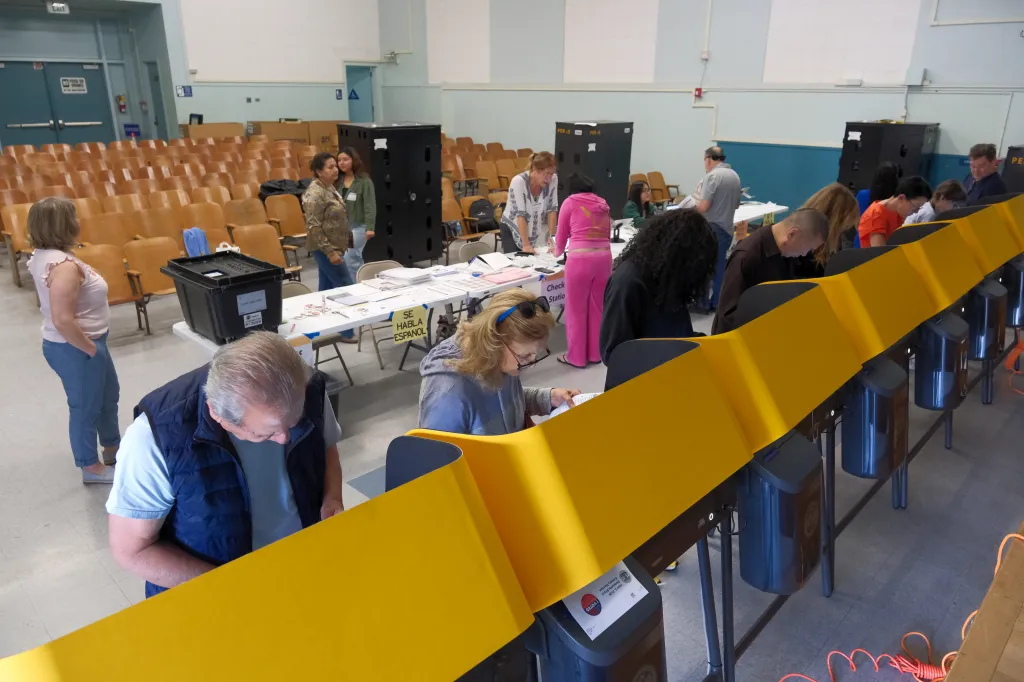 Voters fill out ballots in private booths at a polling place.